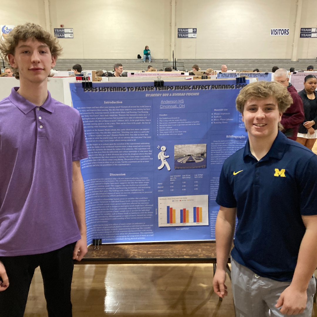 Two students pose next to their science fair project